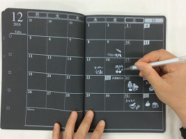 写真２２：視覚障害者用の「黒地ノート」には、太字の「白ペン」の組み合わせがベストです。最近では、ユニバーサルデザインの黒地スケジュール帳も多くあります。