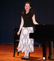 (写真)ピアノの横に立つ田部京子さん