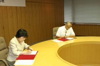 (写真)協定書に調印する岩谷総長と当麻所沢市長