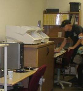 （図１）大学障害学生部門の設備。写真の中央にある白い２台の高速スキャナは電子図書の作製に活用されている。