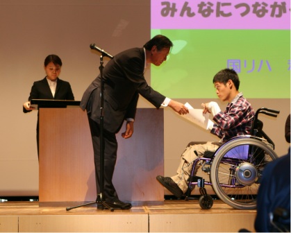 （写真1）開会式時にテーマ表彰をされる和田拓也さん