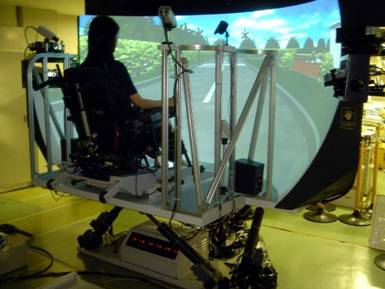 電動車いすシミュレータで、国リハ内の移動のシミュレーションをしている様子です。