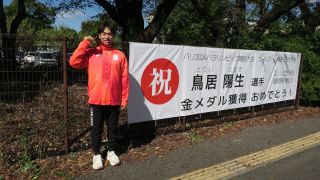 横断幕の横でガッツポーズをする鳥居選手の写真
