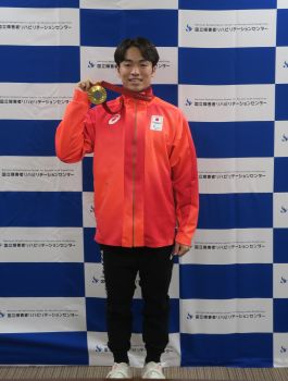 金メダルを持つ鳥居選手の写真