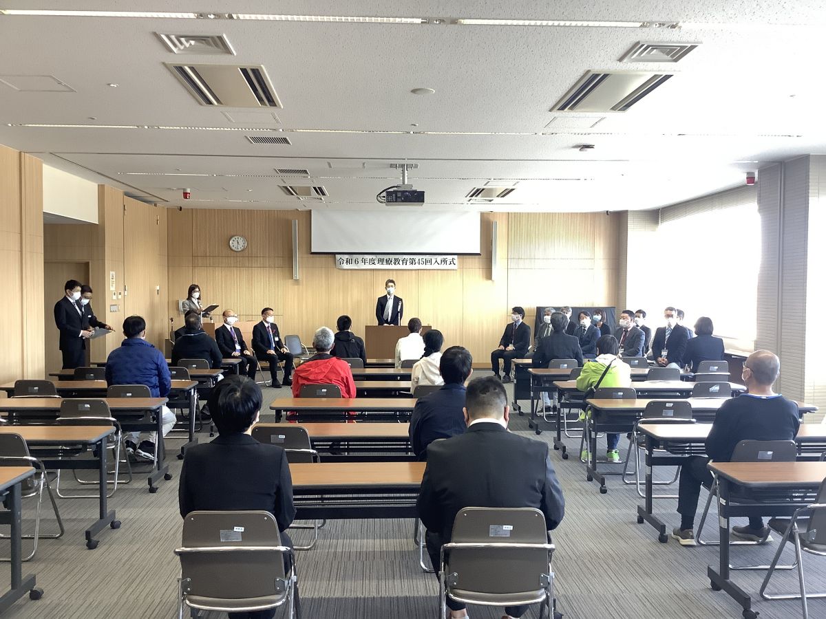 令和6年度理療教育第45回入所式の写真。中央に阿久根自立支援局長、手前に着席するのは１０名の新利用者。