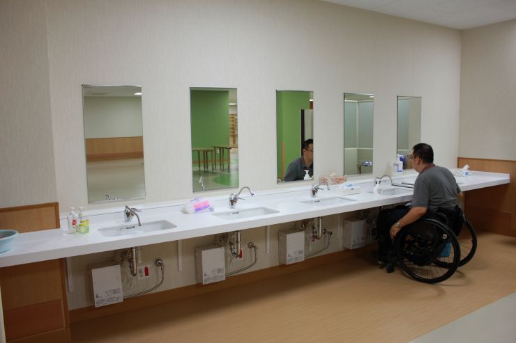 機能訓練棟 食堂の車いす用洗面台5台並んでいる写真