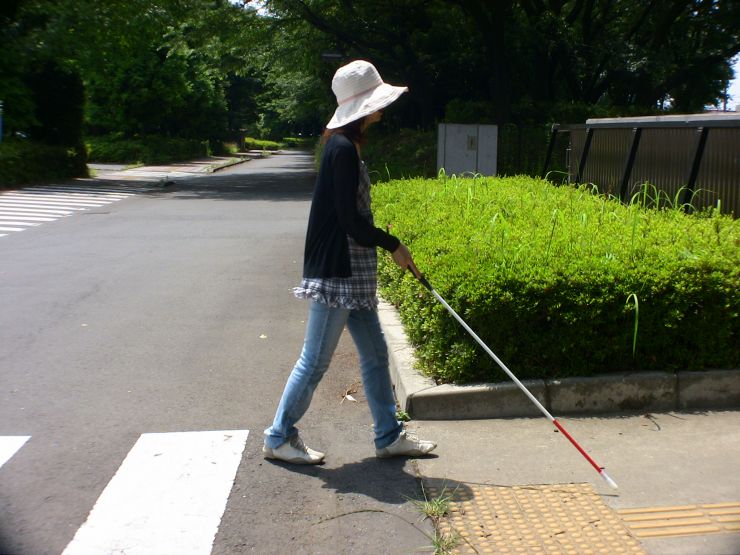 アイマスクを着けて白杖操作訓練を体験する学生の様子