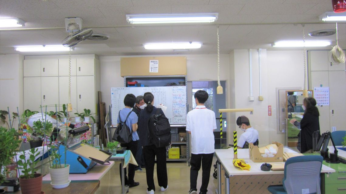 訓練室で職員が見学者に説明をする写真