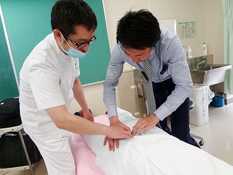 写真：仙腸関節の触診の指導（西村先生：右）