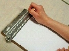 写真3:点字板で点字を打っている様子の写真