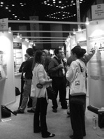 ポスター会場でポスターを読んだり、説明を聞く人々の写真